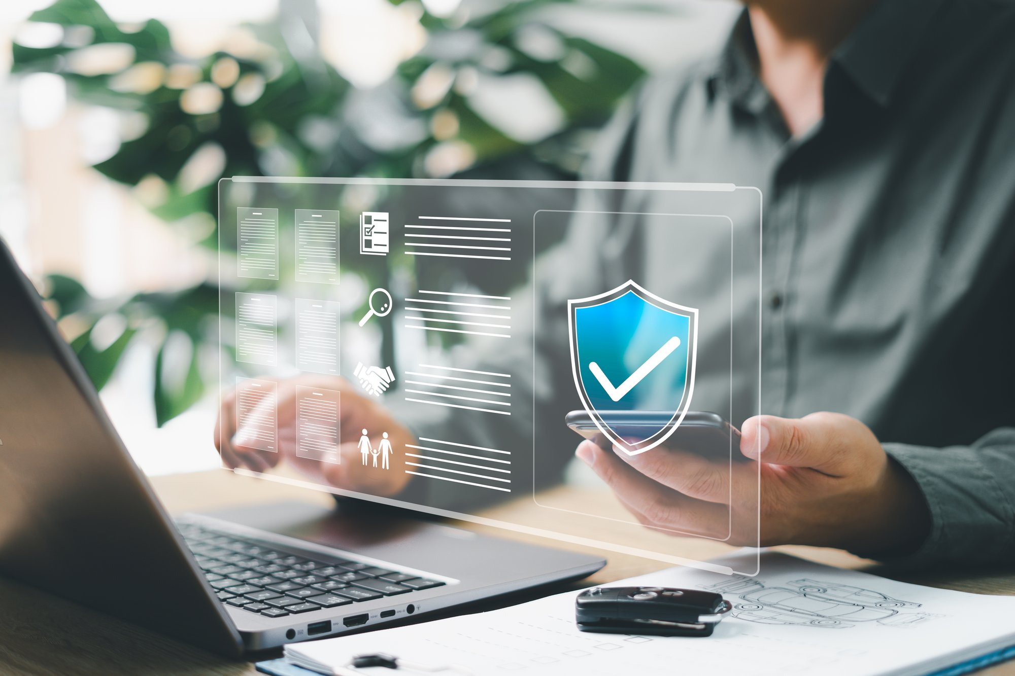 Hands of a man using a laptop with an image of a shield on it. Hands of a man using a laptop with an image of a shield on it.